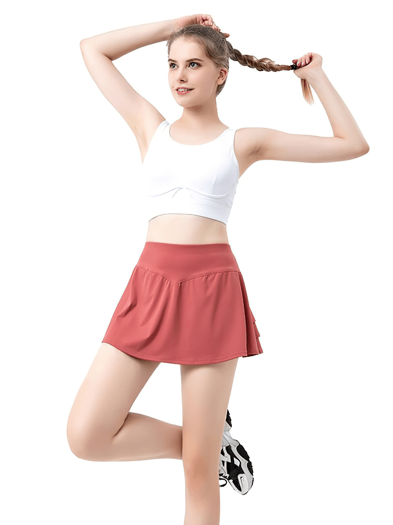 Model wearing Women's Golf Tennis Pleated Skirt-Shorts in pink, featuring lightweight, breathable fabric with a stylish inside pocket.